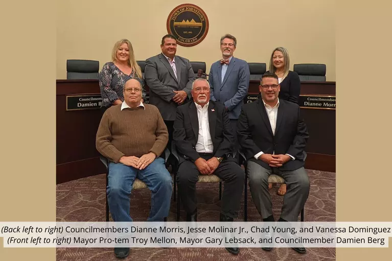 picture of Town Council in a group in the Town Council chambers at Town Hall. From back to front, left to right the Councilmembers are Dianne Morris, Jesse Molinar Jr, Chad Young, Vanessa Dominguez, Troy Mellon, Gary Lebsack (Mayor), and Damien Berg